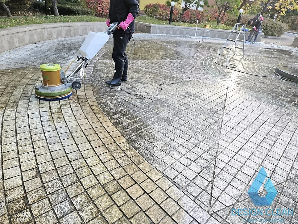 회전 브러시 장비로 광장 바닥을 2차 세척하는 모습